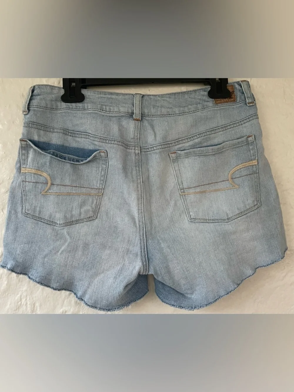 American Eagle women’s mid rise mid wash distressed hem cut off denim shorts; 10